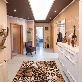 Heller Flur mit afrikanischer Dekoration, Tierfell-Teppich und modernen Möbeln.