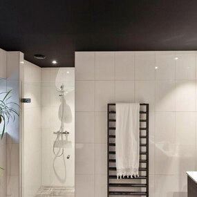 Modernes Badezimmer mit ebenerdiger Dusche, weißen Fliesen und schwarzem Handtuchheizkörper.